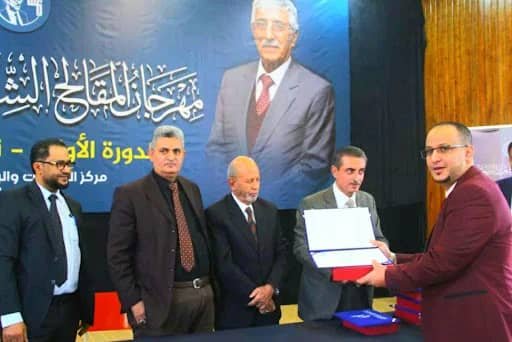 صنعاء تحتضن مهرجان المقالح الشعري الأول..
اكرم حسين.
شهدت العاصمة صنعاء اليوم انطلاق مهرجان المقالح الشعري الأول، في فعالية ثقافية احتفت بإرث شاعر اليمن الكبير الراحل الدكتور عبدالعزيز المقالح، بمشاركة نخبة من الأدباء والكتّاب والمثقفين، وحضور لافت لرموز من الرعيل الأول إلى جانب جيل الشباب والأصوات الشعرية الجديدة.
وفي كلمته خلال افتتاح المهرجان، أكد رئيس اللجنة التحضيرية الشاعر يحيى الحمادي أن تنظيم هذا الحدث يتزامن مع إحياء الذكرى السنوية لرحيل الدكتور المقالح، الشخصية التي شكلت – كما قال – روحاً وموروثاً أدبياً وشعرياً للأجيال المتعاقبة. وأضاف الحمادي أن المقالح لم يكن مجرد اسم في تاريخ الأدب اليمني والعربي، بل كان “روحاً خالدة جعلت من الشعر فضاءً إنسانياً، ومن الأدب جسراً تتقاطع عنده أحلام الأجيال وطاقاتها.”
وأشار الحمادي إلى أن استحضار ذكرى الراحل لا يليق أن يكون مناسبة للحزن والرثاء، بقدر ما هو احتفاء بمنارة أدبية شامخة، مضيفاً أن اللجنة التحضيرية حرصت على أن يكون المهرجان فرصة لعرض نتاج المواهب الشابة التي آمن بها المقالح ودعم حضورها، وأن يتحول الحدث إلى ذاكرة وطنية “لا تخص أسرته فحسب، بل اليمن كلّه من صعدة حتى المهرة.”
وكشف رئيس اللجنة أن الدورة الأولى للمهرجان استقبلت أكثر من 300 قصيدة، بينها 70 قصيدة لشعراء عرب، مشيراً إلى أن لجنة الفرز المكوّنة من:
البرفسور عبد الحميد الحسامي، والدكتور عبد الرحمن الصعفاني، والدكتور إبراهيم أبو طالب، اختارت ما يقارب 50 قصيدة استوفت الشروط وتستحق الوقوف على منصة المهرجان رغم ضيق الوقت. وقد تقرر إتاحة الفرصة لنحو 10 شعراء من الأسماء الجديدة لعرض أعمالهم، إلى جانب نخبة من الشعراء المعروفين، مقدّماً الاعتذار لمن لم تشملهم المشاركة هذا العام، مع التأكيد على إدراج أعمالهم في دورات المهرجان القادمة.
ونوّه الحمادي بأن المهرجان “مكسب لكل الشعراء، وُجد ليُسمِع الصوت الإبداعي لا ليحصي عدد المشاركين”، موجهاً شكره للشعراء العرب الذين بادروا بإرسال نصوصهم رغم أن المهرجان ما يزال في خطواته الأولى، مؤكداً أن اليمن ستكون مستقبلاً محطة مضيافة لكل المبدعين العرب.
وقد قدم عدد من الشعراء مشاركاتهم التي نالت إعجاب الحاضرين، مستكملين بذلك مشروع المقالح ورؤيته في احتضان المواهب الشعرية من مختلف الأعمار.
كما تخلل المهرجان أداء الفنان عبدالرحمن السماوي لأغنيتين من كلمات الراحل المقالح، بمرافقة عازف العود عماد السويدي، في لحظة فنية أضفت على الفعالية طابعاً وجدانياً مؤثراً.
وفي ختام المهرجان، جرى تكريم الشعراء المشاركين واللجنة التحضيرية وأسرة الدكتور المقالح تقديراً لإسهاماتهم وجهودهم في إنجاح هذا الحدث الثقافي الاستثنائي